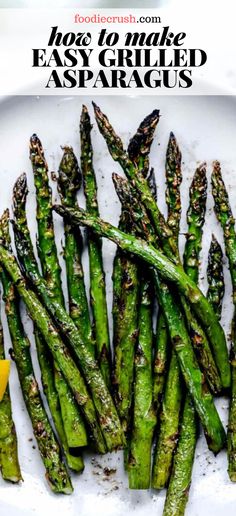 grilled asparagus on a plate with lemon wedges