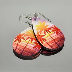 A beautiful pair of wooden sublimated teardrop earrings with a lovely sunset beach and palm tree design. This design is suitable to wear all year round. The earrings have been printed on both the front and back sides.  The design is durable and the earrings are light to wear.  A great accessory have throughout the year or to give as a gift for that special someone.  The colours displayed on a computer screen may vary slightly compared to the real product. While I will endeavour to always have yo Summer Beach Teardrop Earrings, Summer Teardrop Earrings, Palm Tree Design, Double Sided Earrings, Making Bracelets, Jewelry Making Bracelet, Tree Design, Sunset Beach, Tree Designs