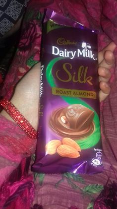 dairy milk silk chocolate bar with almonds in it's wrapper on a bed