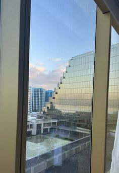 an open window with the view of buildings in the background and a building across the street from it