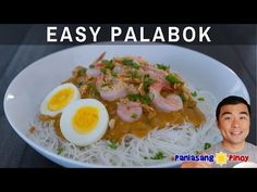 the man is smiling next to his plate of noodles with shrimp and eggs on it