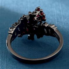 The princess of darkness returns from the dead to appear on this skull ring in her own image. A large red diamond overhangs her crown and evokes the blood flowing from the souls she harvests. Greeting to all of you beautiful goth queens, this gothic skull engagement ring would be perfect for you if you’re looking for a new jewel that would look amazing with any of your outfits, especially if you put some black nail polish on those beautiful hands of yours, this ring is split into 3 colors, the d Gothic Black Skull Ring, Black Fantasy Rings As Gift, Black Fantasy Style Rings As Gift, Fantasy Style Black Ring For Gift, Gothic Ruby Promise Ring, Elegant Black Skull Ring For Halloween, Black Ruby Jewelry For Wedding, Black Ruby Wedding Jewelry, Wedding Black Ruby Jewelry