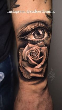 an eye with a rose tattoo on the arm is shown in black and grey colors