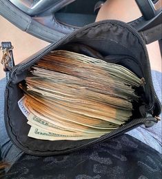 a bag filled with lots of money sitting on top of a seat next to a person