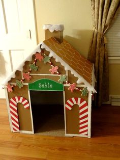 a dog house made out of cardboard with gingerbreads and candy canes