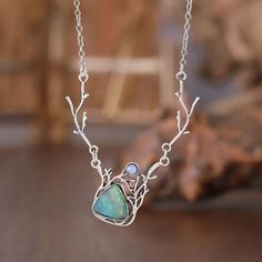 the necklace is made with silver wire and labradorite stone, on a wooden table