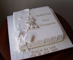 a cake that is sitting on top of a table with white frosting and decorations