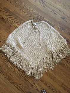 Never worn vintage poncho!  So cozy and warm!  Circa 1990s yet looks like the 70s!  This would go with any outfit!  Nice caramel color.  Front tie closure.  Will fit any body type and so versatile!  36 inches across the front.  Approximately 34 inches long.  15% wool, 85% acrylic. No itching!  Women's size M.  Please message me with any questions! Casual One Size Poncho With Fringe, Casual One-size Poncho With Fringe, Cream Casual Poncho, One Size Fits All, Cream Casual Poncho One Size, Cozy Winter Poncho With Fringe, Casual One Size Chunky Knit Poncho, One Size Vintage Poncho For Winter, Vintage One-size Winter Poncho, Vintage Winter Poncho One Size