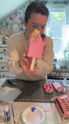 a woman holding an ice cream bar with sprinkles on it