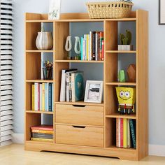 a bookshelf filled with lots of books next to a plant in a room