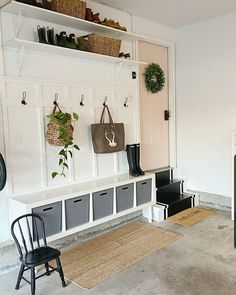 a room with a bench, chair and coat rack on the wall next to it