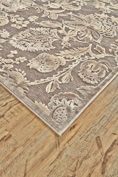 a brown and beige rug on top of a wooden floor