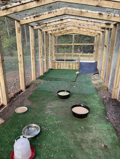 the inside of a chicken coop with several bowls on the ground