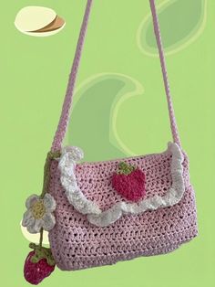 a crocheted purse with strawberries hanging from it's side on a hook