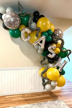 balloons are arranged in the shape of letters that spell out, and balloon garlands hang from the ceiling