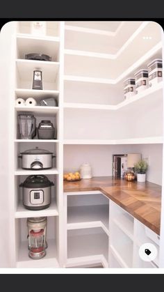 a kitchen with white shelves and wooden counter tops