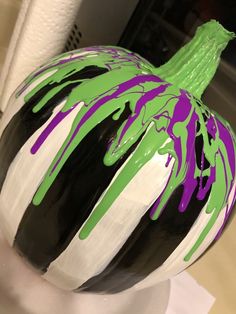 a black, white and green vase sitting on top of a table