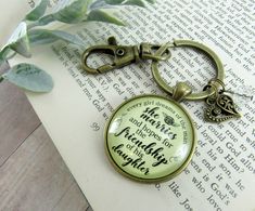 a keychain with a quote on it sitting on top of an open book