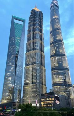 two very tall skyscrapers in the middle of a body of water at night time