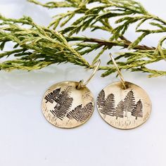 "Tree Earrings - Winter Earrings - Forest Earrings - Brass Gold Earrings - Gift for her - Stocking Suffer - Pine Earrings A little forest for your ears.... 5/8\" brass disks are stamped with little pine trees, and given a rustic finish. They hang from hand formed gold filled earwires. The earrings dangle about 1\"." Stocking Suffers, Forest Earrings, Little Forest, Winter Earrings, Tree Earrings, Earring Tree, Brass Gold, Pine Trees, Earrings Dangle