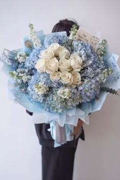 a woman holding a bouquet of flowers in her hands with an envelope on top of it