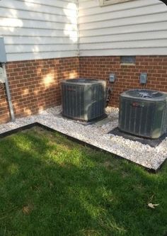 two air conditioners sitting on the side of a house