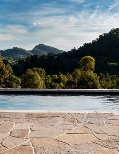 an empty swimming pool surrounded by trees and mountains