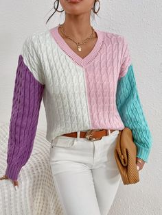 a woman wearing white pants and a pink sweater