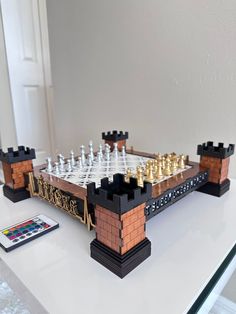 a lego chess set sitting on top of a white table next to a remote control