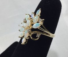 The past will always return in the fashion world and this piece is back for round two! In the 1920's ladies of class wore the most opulent dresses with jewelry to match. As the years continued, jewelry makers tailored pieces to fashion and trends which resulted in affordability for style. Presenting this Beautiful Ladies Vintage 14k Gold Opalescent White Opal Designer Ring Featuring Diamond Accents With Floral Inspired Design. This wonderful ring boasts 12 Marquise Cut Opals measuring 3-4 mm lon Elegant 14k Gold Opal Ring For Formal Occasions, Elegant Yellow Gold Opal Ring For Formal Occasions, Formal Opal Ring, Victorian Opal Ring In 14k Gold For Formal Occasions, Elegant Multi-stone Opal Ring For Collectors, Elegant Opal Ring For Formal Occasions, Elegant Formal Opal Ring, Elegant Opal Ring With 17 Jewels For Anniversary, Victorian Multi-stone Opal Ring For Formal Occasions