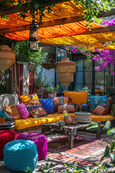 an outdoor living area with lots of colorful cushions and pillows on the couches,