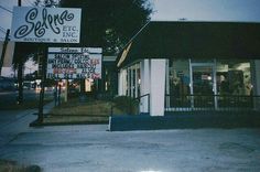 a store front with signs on it at night