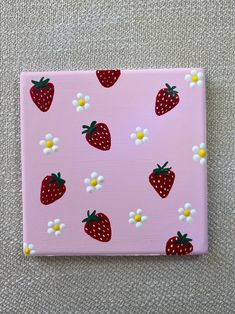 a pink canvas with strawberries and daisies on it