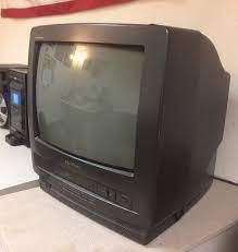 an old television sitting on top of a table next to other electronics and equipment in front of the american flag