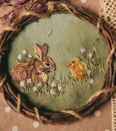 a close up of a embroidery on a piece of cloth with a bunny and chick