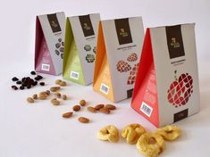 three bags with nuts and raisins next to each other on a white surface