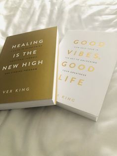 two books sitting on top of a bed next to each other in front of a white sheet