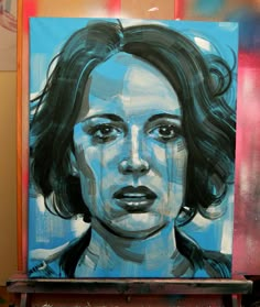 a painting of a woman's face is shown in front of a red and blue background