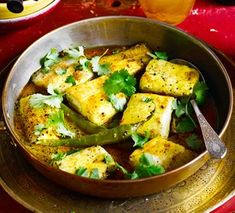 a bowl filled with tofu and cilantro on top of a table