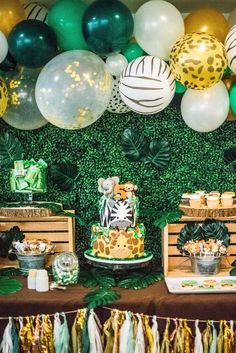 a jungle themed birthday party with balloons and desserts