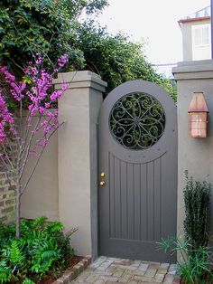 an entrance to a home with purple flowers in the foreground