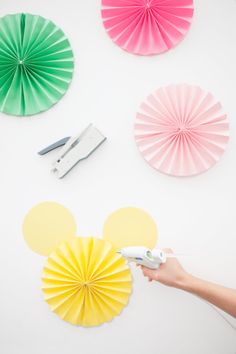 paper fans and scissors are on the wall