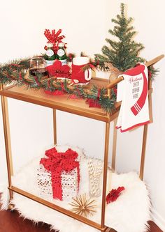 a wooden table with christmas decorations on it and a small tree in the corner next to it