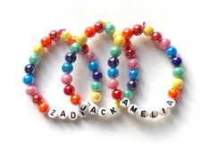 three bracelets with letters and beads that spell out the word bead / acrylic jewelry