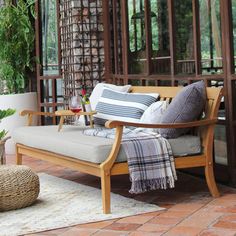 a wooden bench sitting on top of a patio next to a potted plant and window