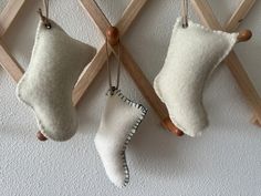 two christmas stockings hanging on the wall next to wooden pegs and a small ornament