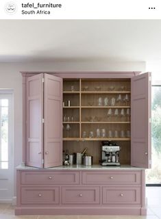 a kitchen with pink cabinets and marble counter tops