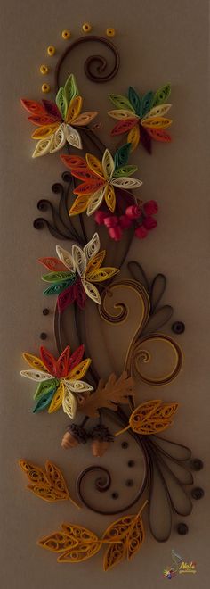 an intricately designed wall hanging with flowers and leaves