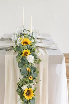 the table is decorated with sunflowers and greenery for an elegant touch to it