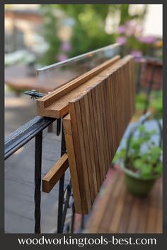 a wooden bench sitting on top of a balcony next to a potted green plant